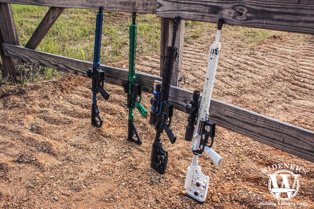 a photo of ar-15 rifles leaning up against a fence