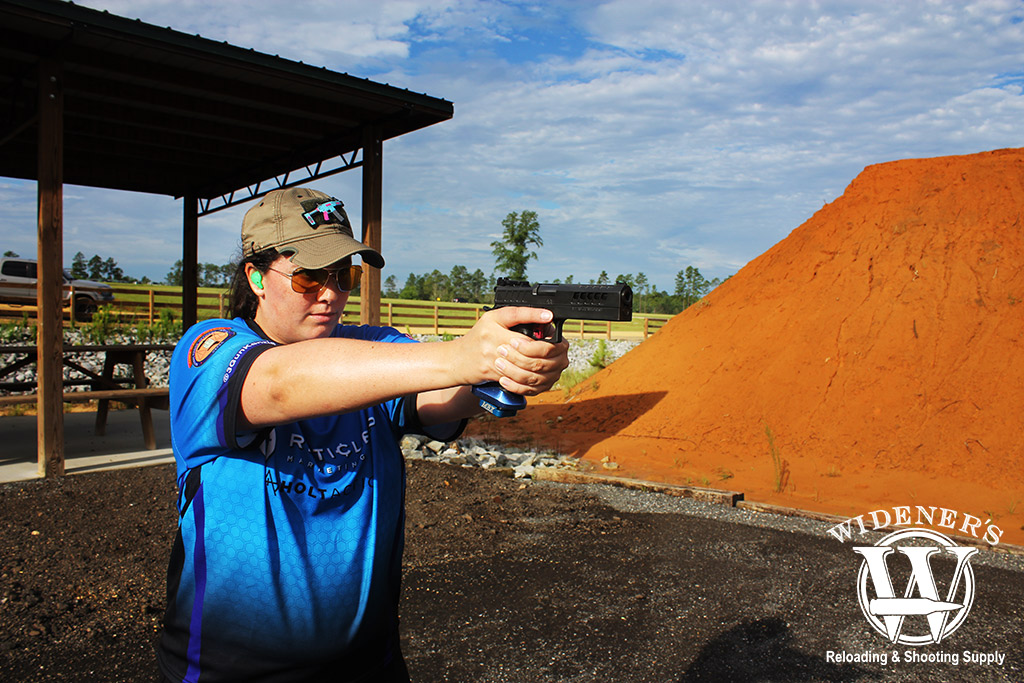 a photo of a female shooter shooting a pistol at an outdoor gun range