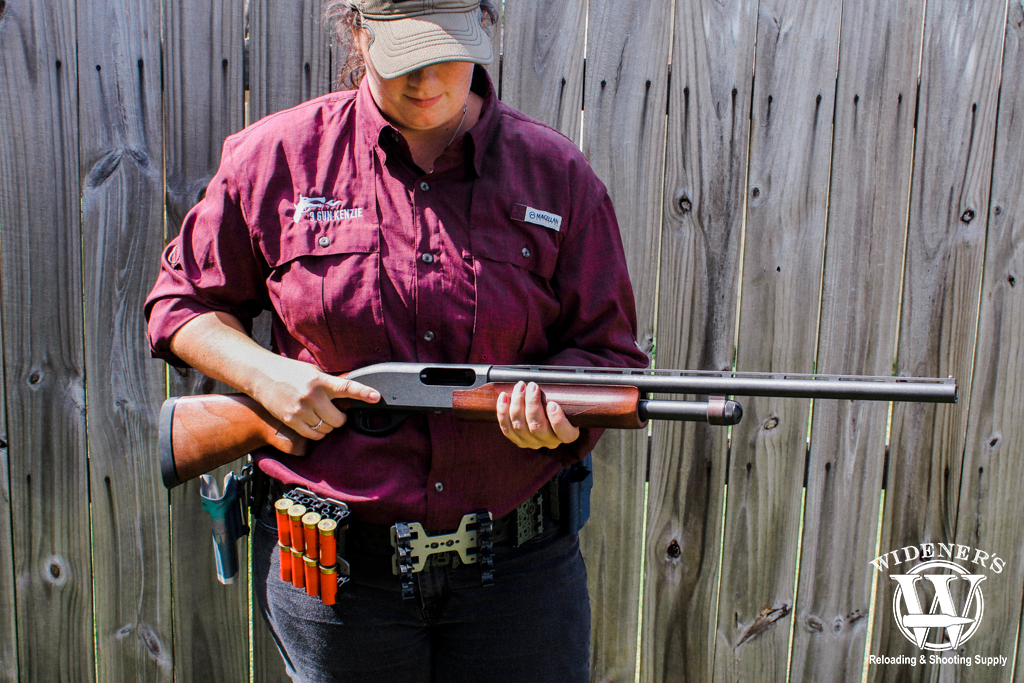 a photo of a female holding a pump-action shotgun
