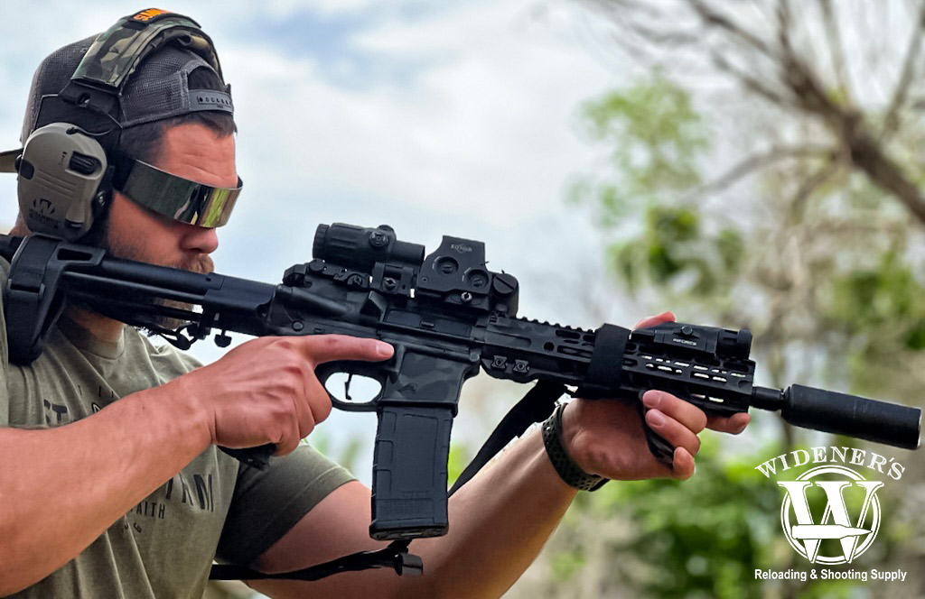 a photo of a man shooting a suppressed rifle chambered in 300 BLK