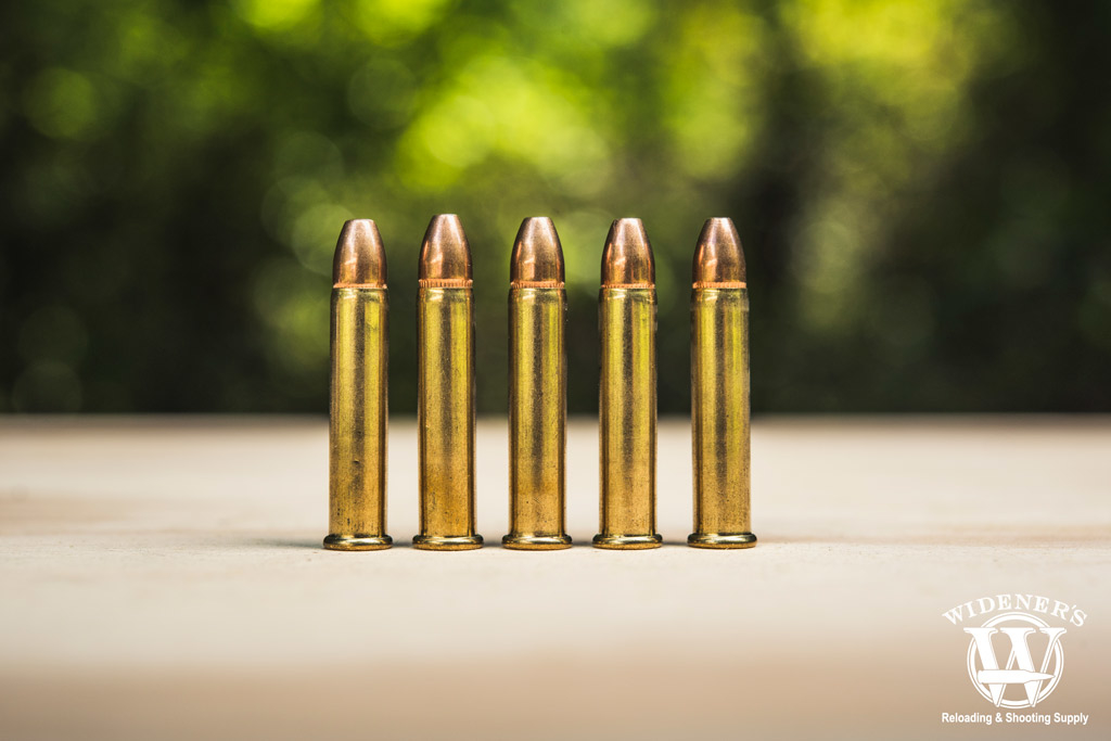 a photo of 22 wmr bullets on a sheet of plywood outdoors