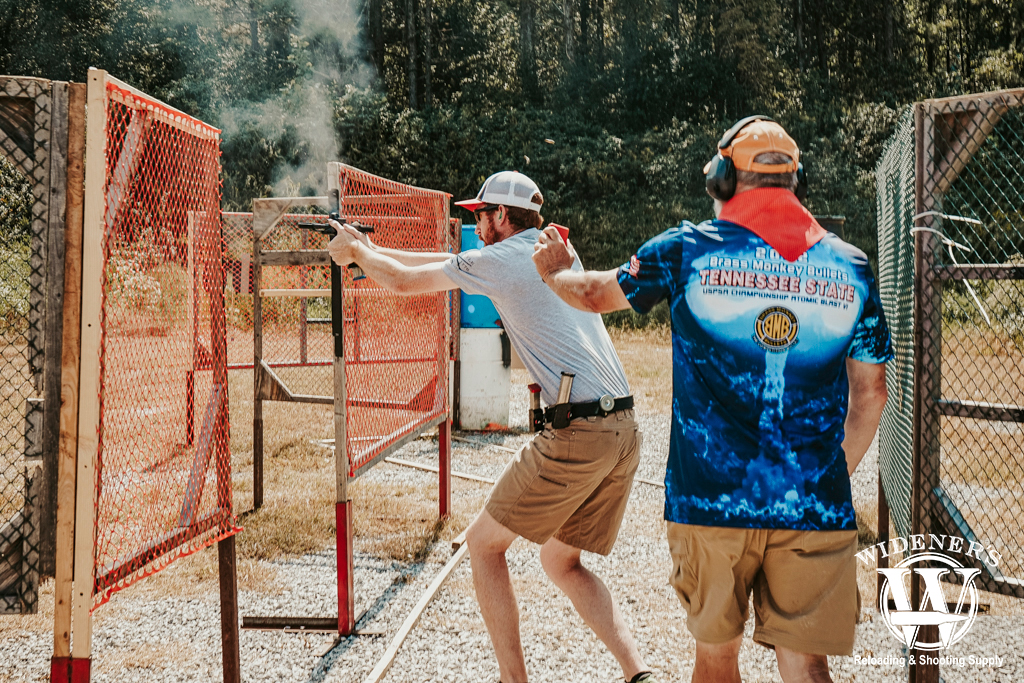 a photo of a man shooting in a USPSA competition