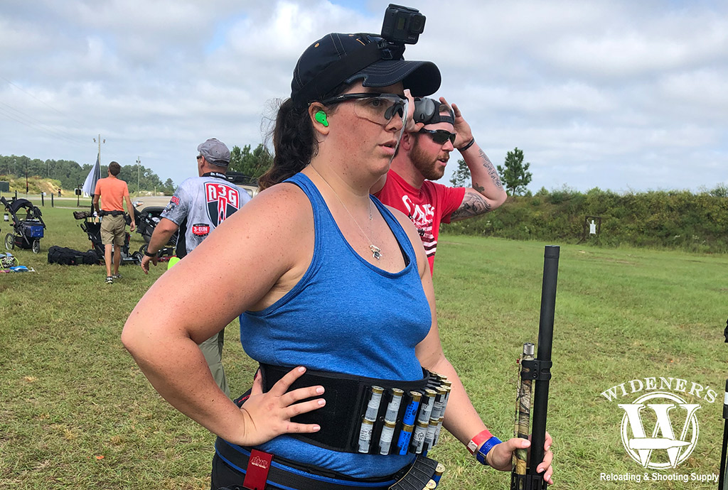 a photo of a female 3 gun competition competitor with a 12 gauge shotgun