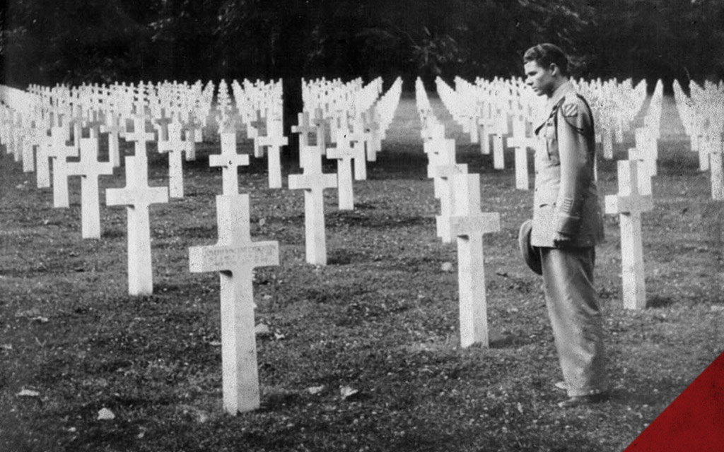 a photo of Audie Murphy viewing graves after WWII in France