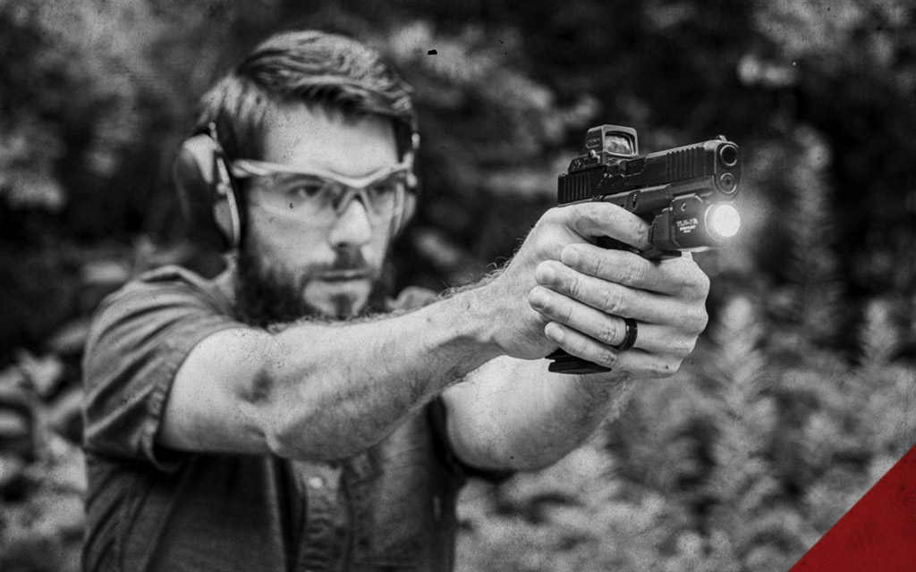 a photo of a man shooting a glock handgun