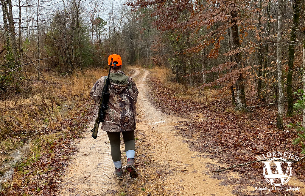 a photo of a female deer hunter in the woods