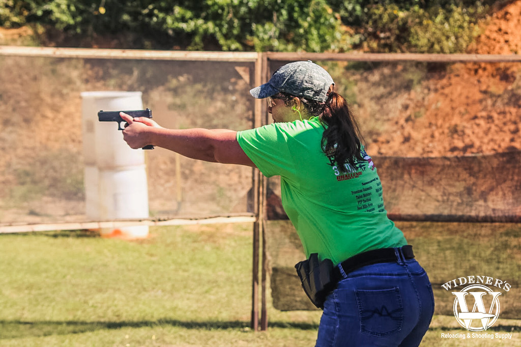 a female competition shooter running at a gun range