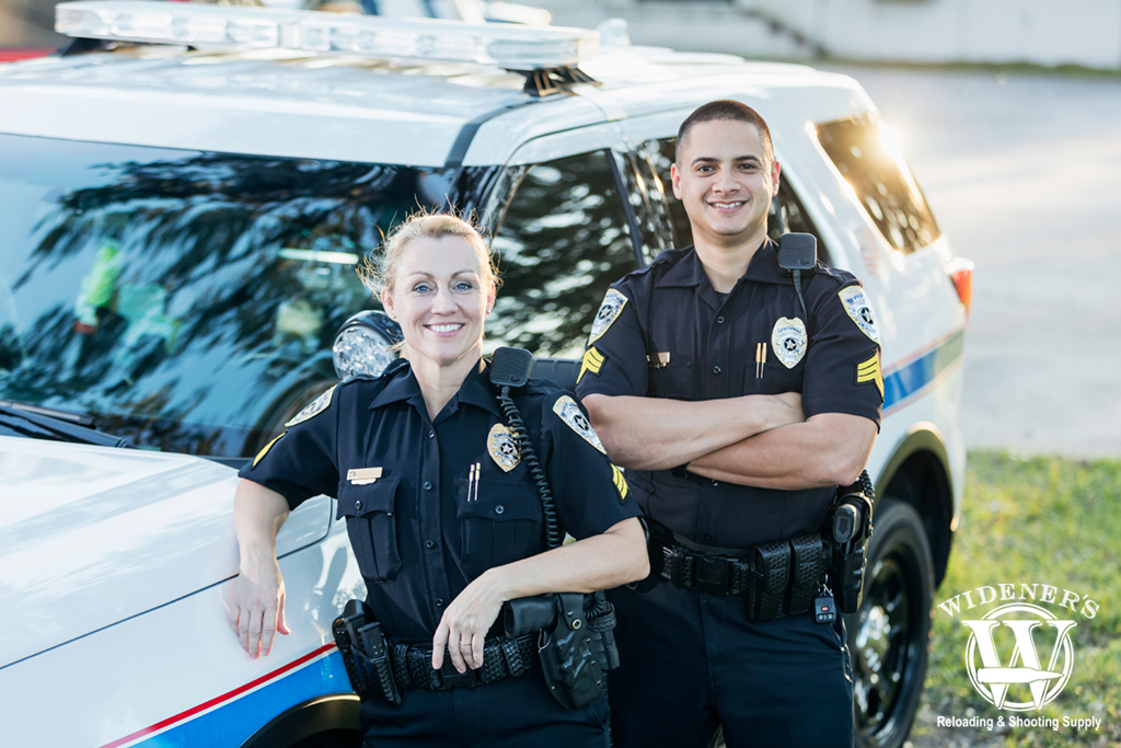 two police officers by their squad vehicle a photo of two police officers by their squad vehicle