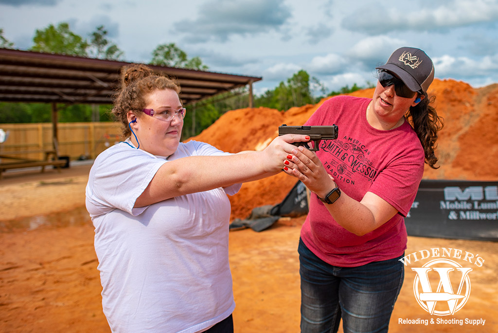 a photo of a woman at a gun range practicing proper trigger discipline 