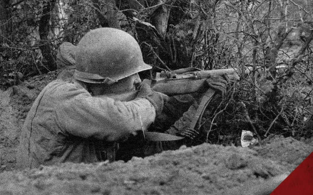 a historical photo of a soldier using a m1 garand in battle